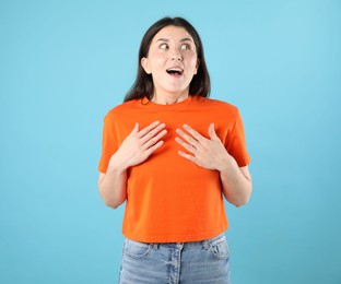 Photo of Portrait of surprised woman on light blue background