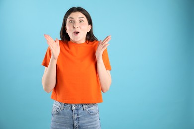 Photo of Portrait of surprised woman on light blue background, space for text