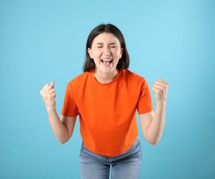 Photo of Portrait of emotional woman on light blue background