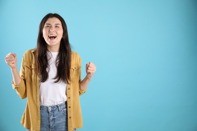 Photo of Portrait of emotional woman on light blue background, space for text