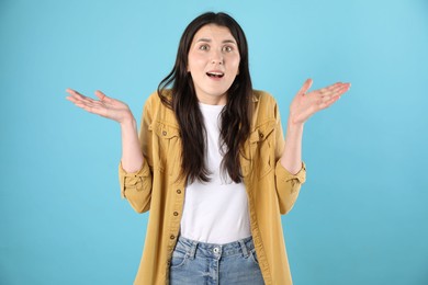 Photo of Portrait of surprised woman on light blue background
