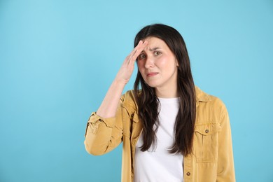 Photo of Portrait of confused woman on light blue background, space for text
