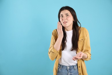 Photo of Portrait of confused woman on light blue background, space for text