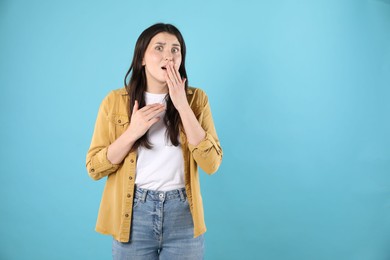 Photo of Portrait of surprised woman on light blue background, space for text
