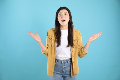 Photo of Portrait of surprised woman on light blue background