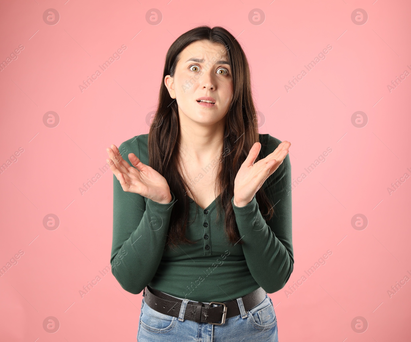Portrait of confused woman on pink background Photo of Portrait of confused woman on pink background