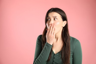 Photo of Portrait of surprised woman on pink background, space for text