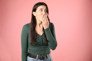 Photo of Portrait of surprised woman on pink background, space for text