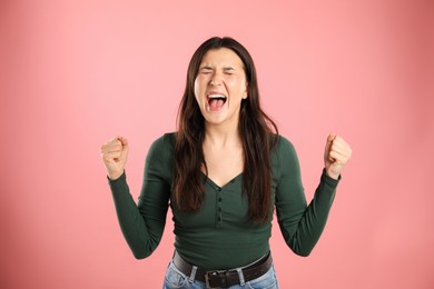 Photo of Portrait of emotional woman on pink background