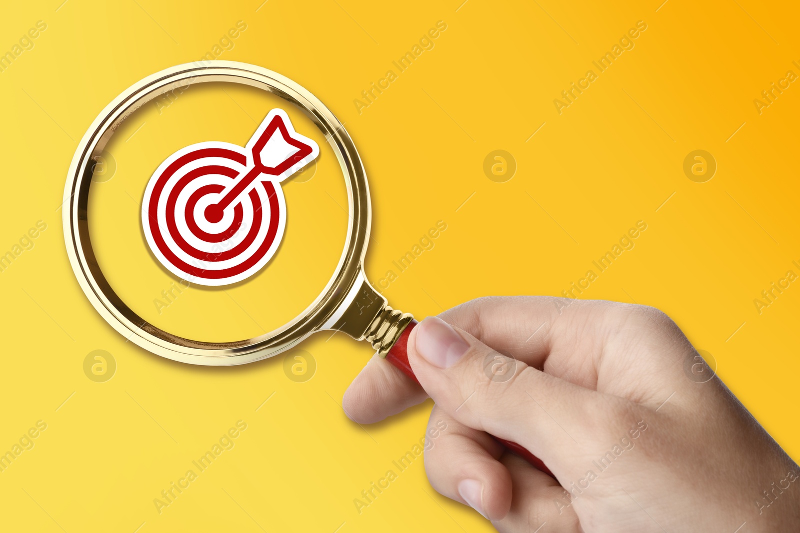 Woman holding magnifying glass with target and arrow inside against orange background, closeup Image of Woman holding magnifying glass with target and arrow inside against orange background, closeup