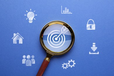 Image of Magnifying glass over target with arrow on blue background, top view. Different icons around