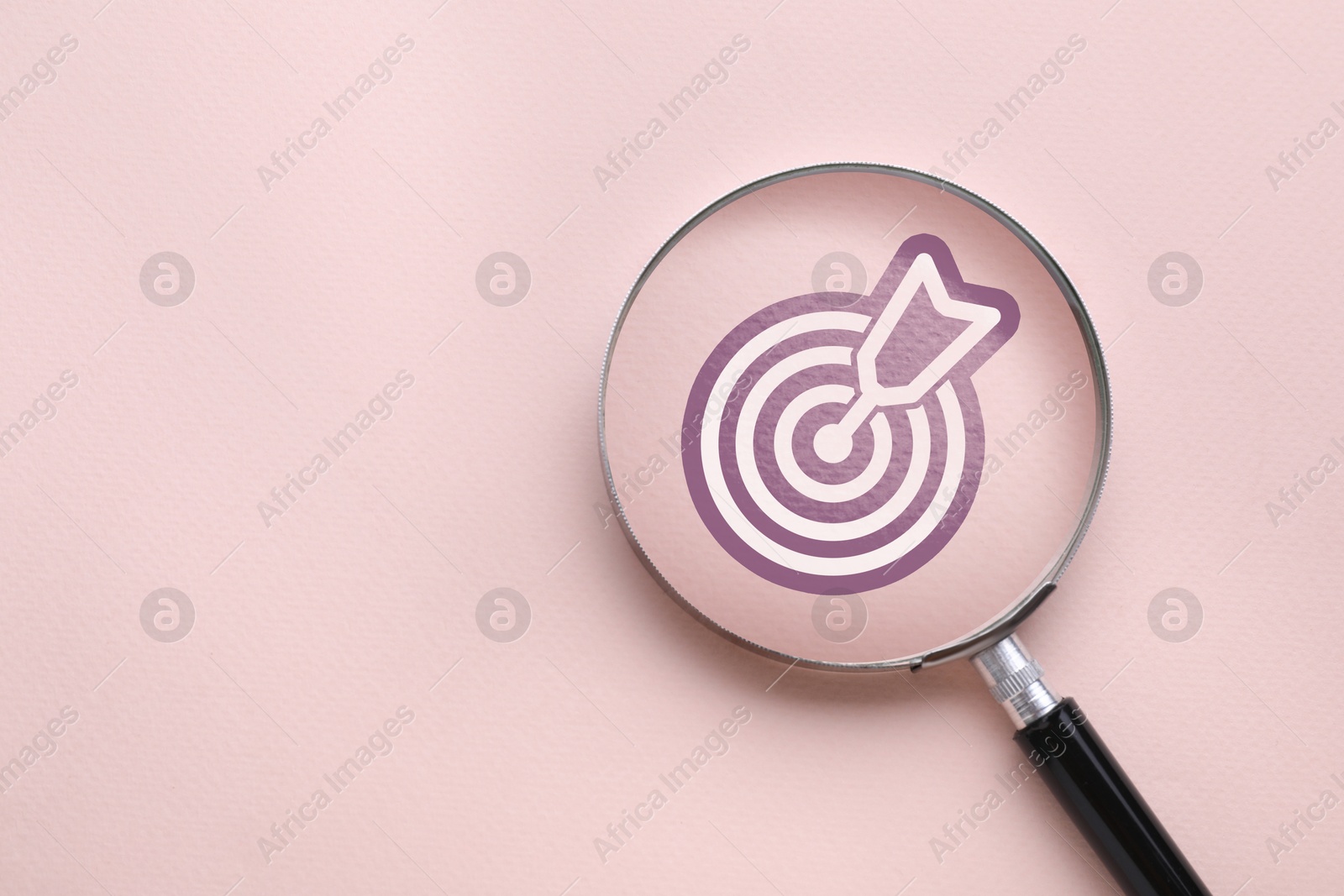 Magnifying glass over target with arrow on pink background, top view Image of Magnifying glass over target with arrow on pink background, top view