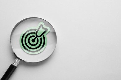 Image of Magnifying glass over target with arrow on white background, top view