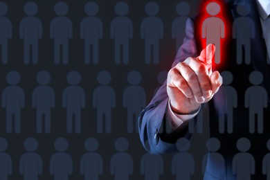 Image of Dismissal. Businessman choosing human figure on virtual screen against black background, closeup