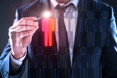 Image of Dismissal. Businessman choosing human figure on virtual screen against black background, closeup
