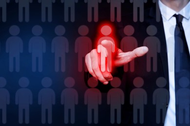 Image of Dismissal. Businessman choosing human figure on virtual screen against dark blue background, closeup