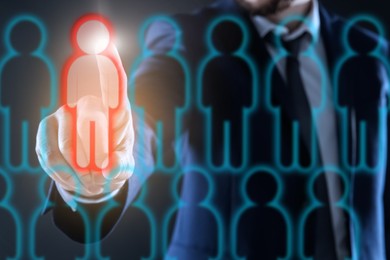 Image of Dismissal. Businessman choosing human figure on virtual screen against black background, closeup