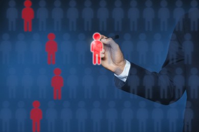 Image of Dismissal. Businessman choosing human figures on virtual screen against dark blue background, closeup
