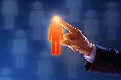 Image of Dismissal. Businessman choosing human figure on virtual screen against dark blue background, closeup