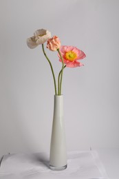 Photo of Beautiful poppy flowers in vase on light grey background