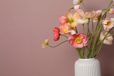Photo of Beautiful poppy flowers in vase on pink background, closeup. Space for text
