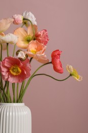 Photo of Beautiful poppy flowers in vase on pink background, closeup