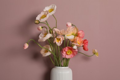 Photo of Beautiful poppy flowers in vase on pink background, closeup