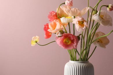 Photo of Beautiful poppy flowers in vase on pink background, closeup. Space for text