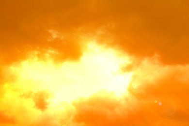 Image of Orange sky with clouds during hot summer weather