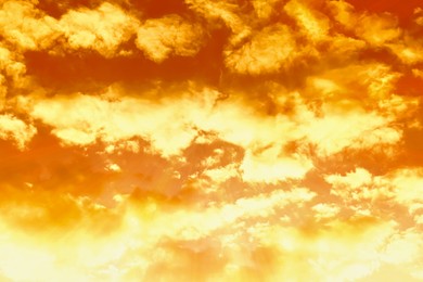 Image of Orange sky with clouds during hot summer weather