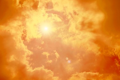 Image of Orange sky with clouds during hot summer weather