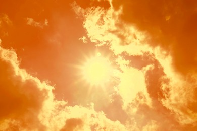 Image of Orange sky with clouds during hot summer weather