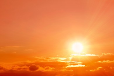 Image of Orange sky with clouds during hot summer weather