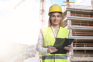 Image of Engineer with clipboard and unfinished building, double exposure