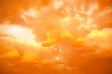 Image of Orange sky with clouds during hot summer weather