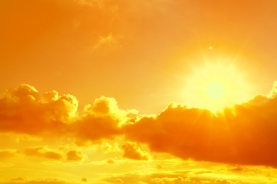 Image of Orange sky with clouds during hot summer weather
