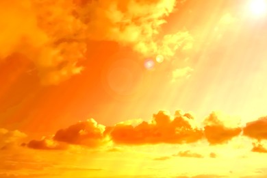Image of Orange sky with clouds during hot summer weather