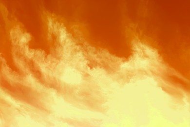 Image of Orange sky with clouds during hot summer weather