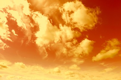 Image of Orange sky with clouds during hot summer weather