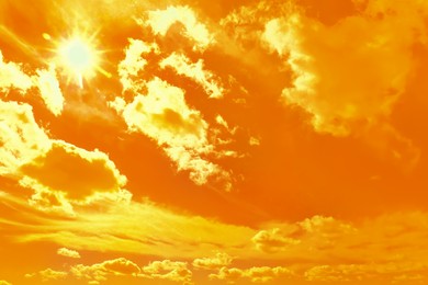 Image of Orange sky with clouds during hot summer weather