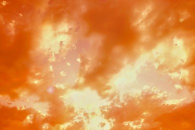 Image of Orange sky with clouds during hot summer weather