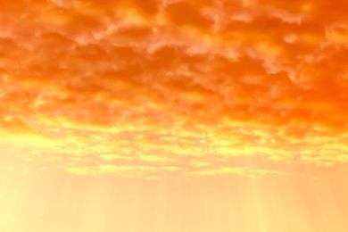 Image of Orange sky with clouds during hot summer weather