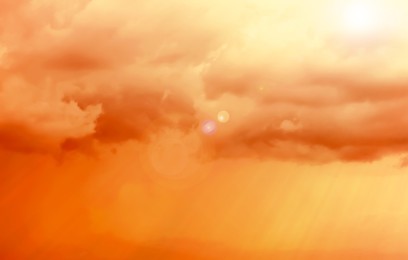 Image of Orange sky with clouds during hot summer weather