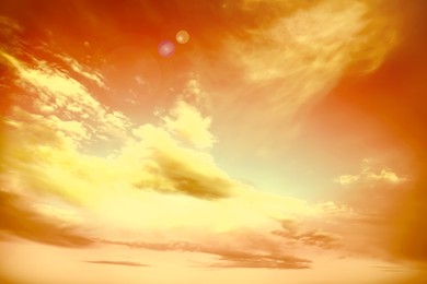 Image of Orange sky with clouds during hot summer weather