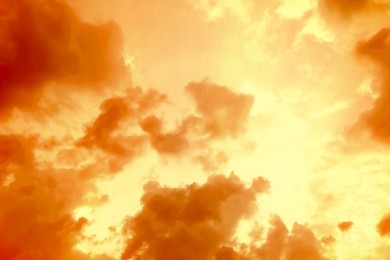 Image of Orange sky with clouds during hot summer weather