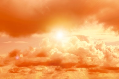 Image of Orange sky with clouds during hot summer weather