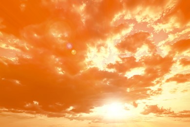 Image of Orange sky with clouds during hot summer weather
