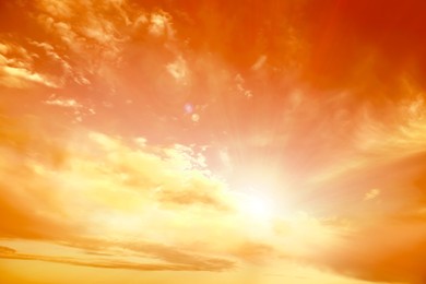 Image of Orange sky with clouds during hot summer weather