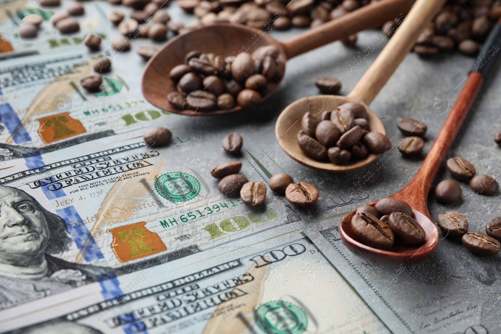 Coffee price rising. Dollars and spoons with roasted coffee beans Image of Coffee price rising. Dollars and spoons with roasted coffee beans