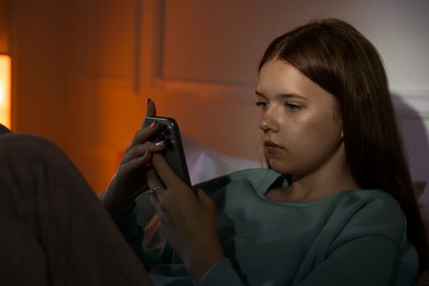 Photo of Beautiful teenage girl using smartphone at home